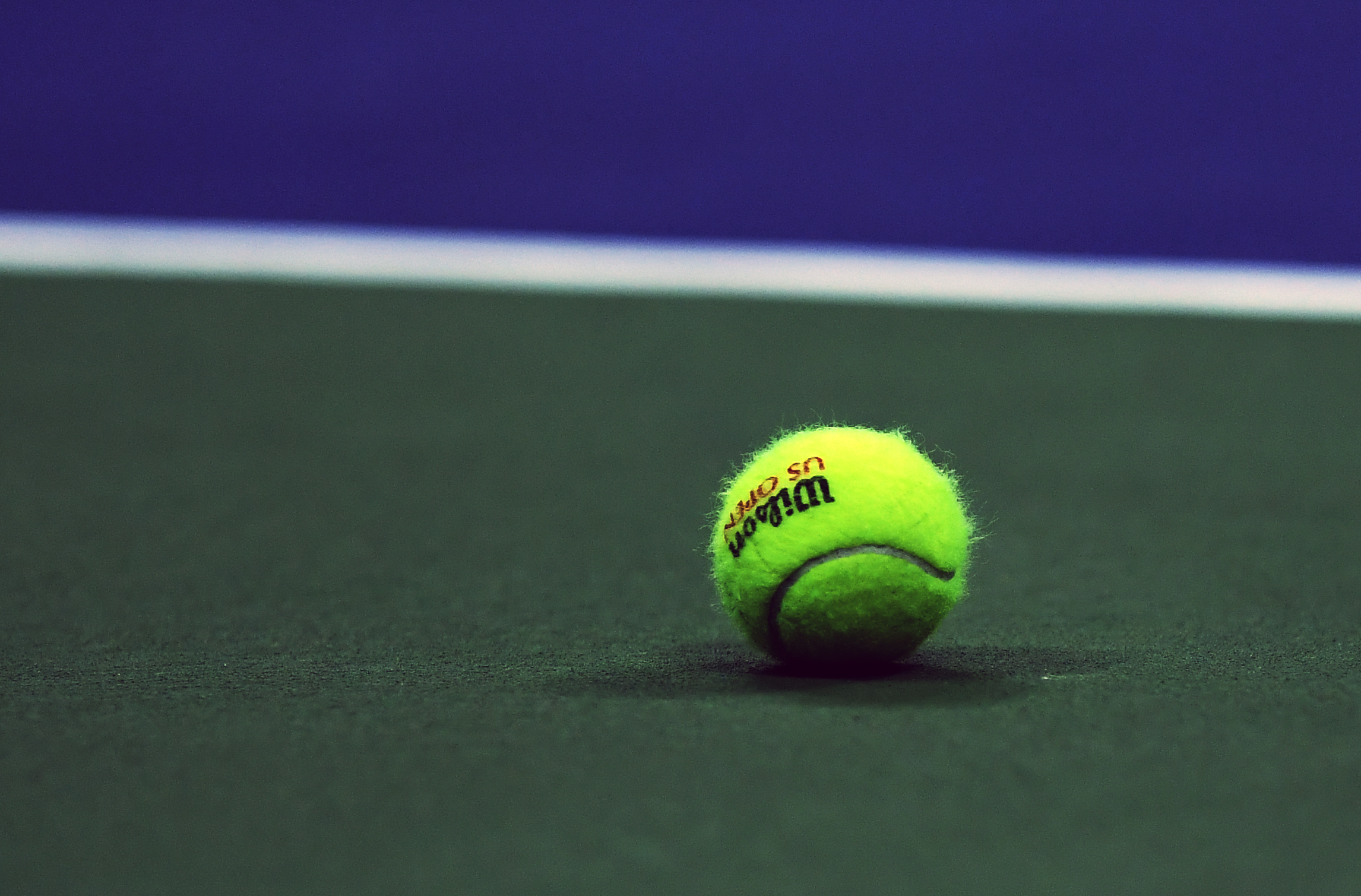 A Wilson tennis ball used at the US Open lying on the hard court.