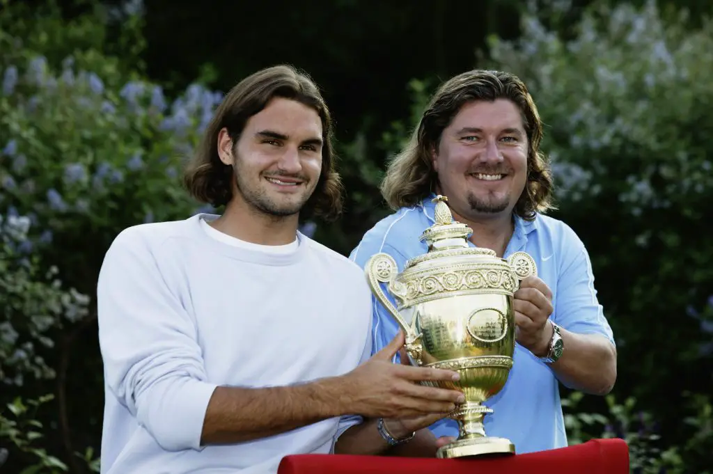 2003 Wimbledon men's singles champion Roger Federer of Switzerland poses with the trophy with his coach Peter Lundgren.
