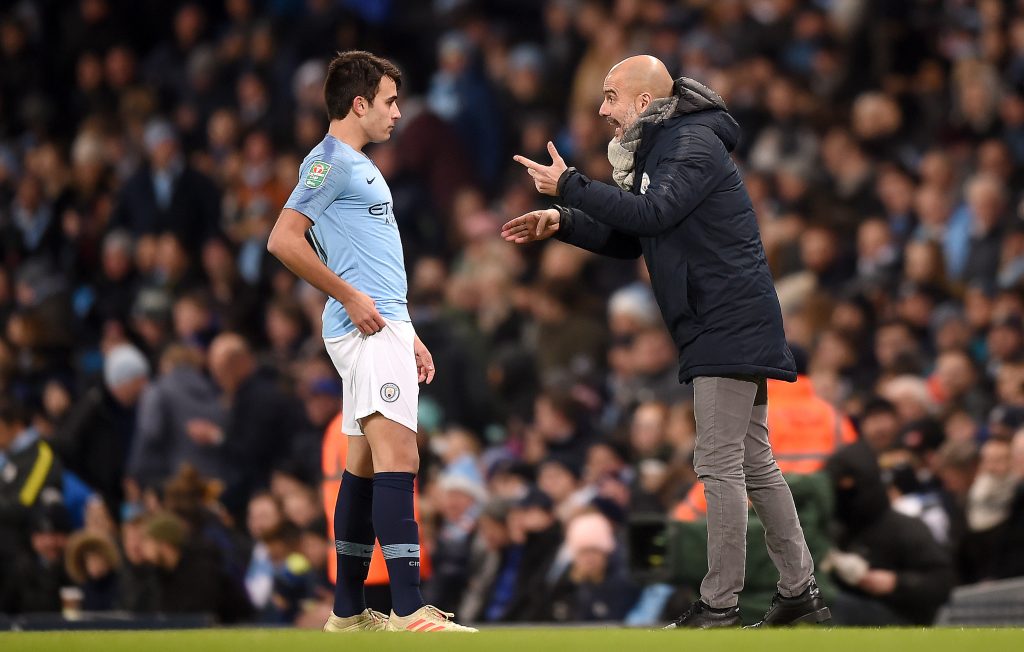 Manchester City boss Pep Guardiola giving instructions to Eric Garcia during a match.