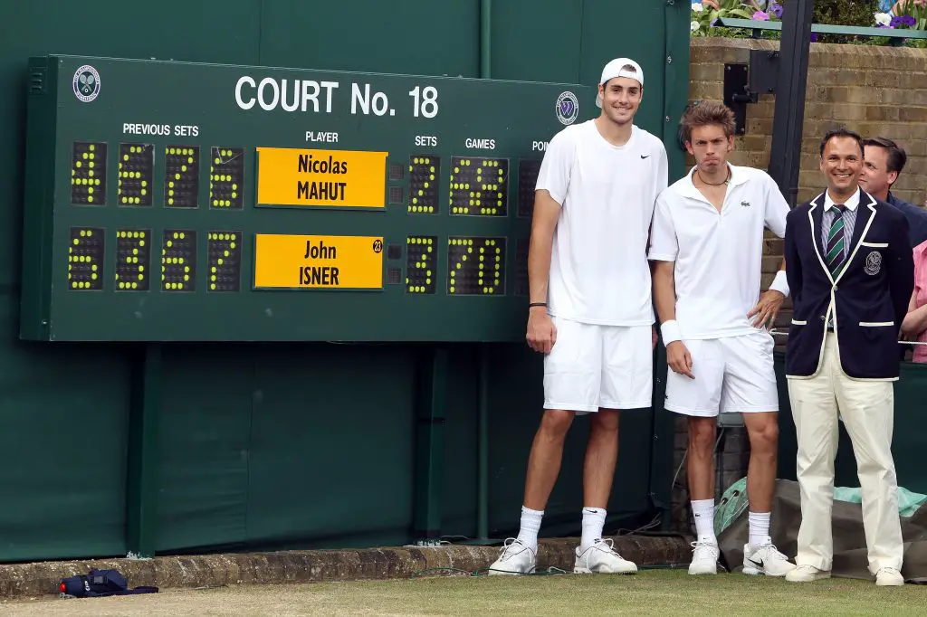 The iconic photo of John Isner and Nicolas Mahut posing in front of the scoreboard after recording the longest match to be played in Grand Slam tennis history during the 2010 Wimbledon.